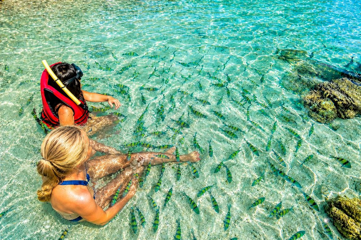 Children enjoying safe snorkeling among tropical fish near coral reefs during a guided Krabi Boat Tours excursion in Thailand